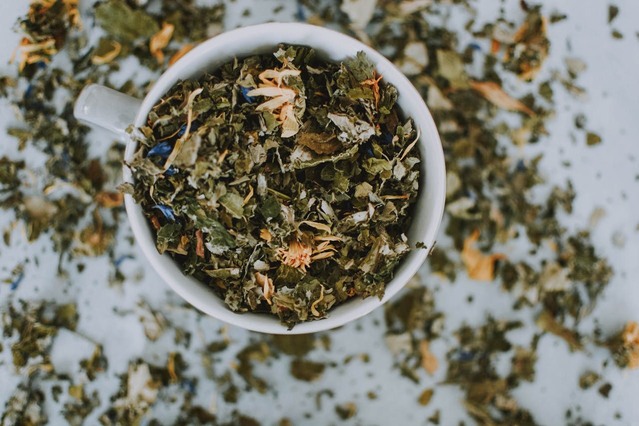 Home Overhead shot of a cup with a blend of dried herbal tea leaves and flowers.