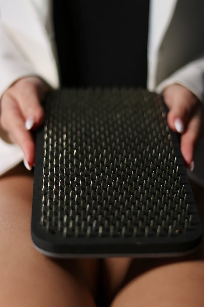 Home A person holding an acupressure massage mat, focusing on the spikes.